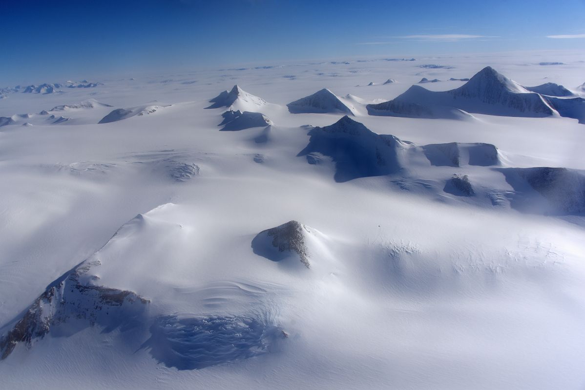 04G Mountains Pop Up From The Surrounding Glacier From Airplane Flying From Union Glacier Camp To Mount Vinson Base Camp